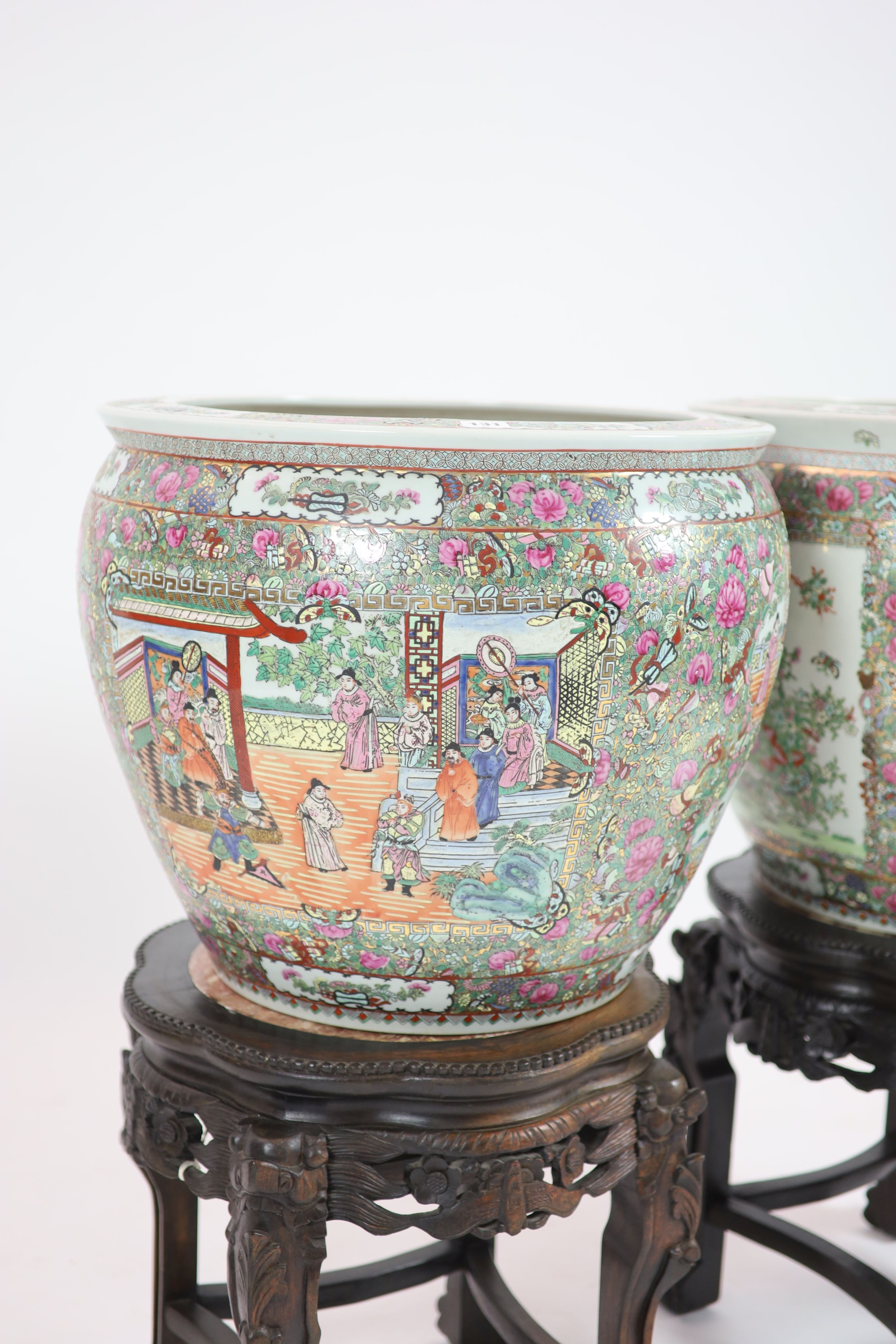 A pair of Chinese famille rose ‘goldfish’ bowls, 56cm diameter, with ebonised and marble inset stands, total height 91cm